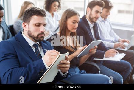 Business training, people making notes at seminar Stock Photo