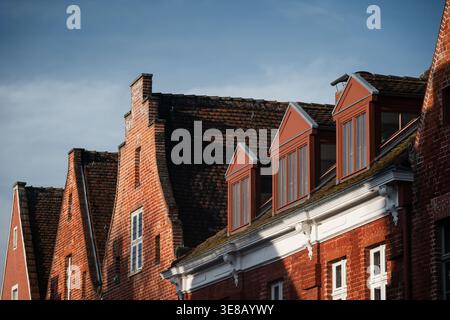 Red brick facades and dormer windows. Close-up of historic red brick houses with distinctive dormer windows and stepped gables in the Dutch Quarter. Stock Photo