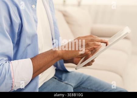 Close up hands of man using digital tablet Stock Photo