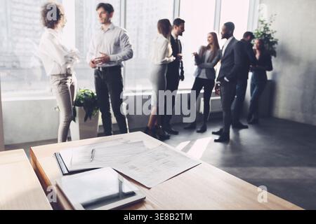 Business document on the desk, office colleagues talking Stock Photo