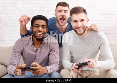 Gamers. Excited men playing video game at home Stock Photo