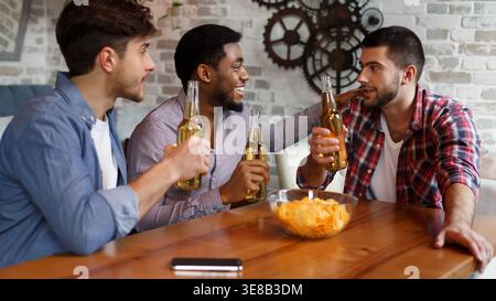 Mates Eating Chips And Drinking Beer In Pub Stock Photo