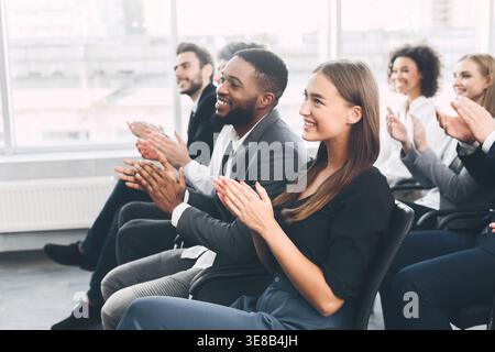 Diverse business team greeting speaker with applause Stock Photo