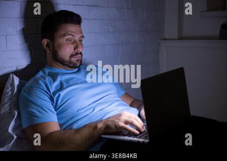 Man using laptop computer doing hard work at night Stock Photo