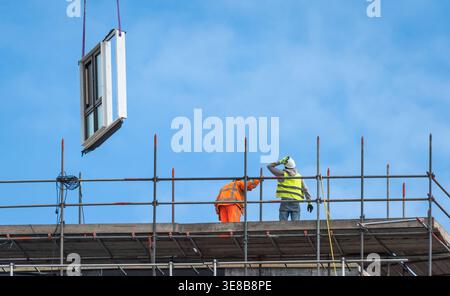 Construction workers at modern high-rise building site, urban development and engineering industry concept Stock Photo