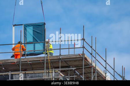 Construction workers at modern high-rise building site, urban development and engineering industry concept Stock Photo