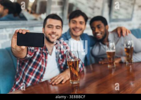 Men taking selfie and drinking beer in bar Stock Photo