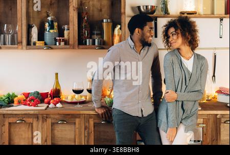 Lovely black couple standing in cozy kitchen Stock Photo