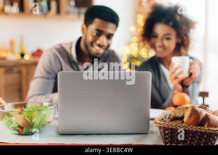 African-american man working on laptop in kitchen Stock Photo
