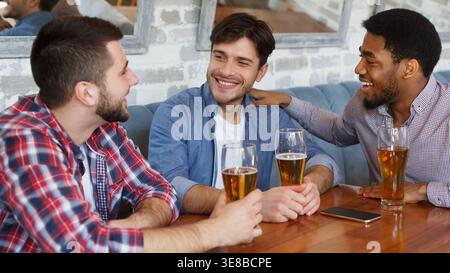 Diverse Friends In Bar Drinking Beer And Resting Stock Photo
