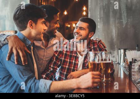 Old friends drinking beer and talking in pub Stock Photo