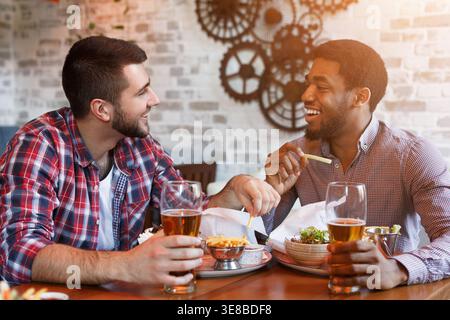 Rest In Bar. Men Drinking Beer And Eating French Fries Stock Photo