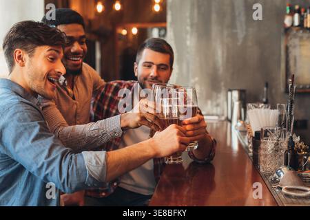 Male Friends Drinking Beer And Talking In Bar Stock Photo