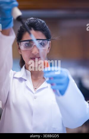 Middle Eastern female lab technician performing blood testing with pipette in medical laboratory Stock Photo