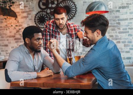 Diverse friends having fun and drinking beer in bar Stock Photo
