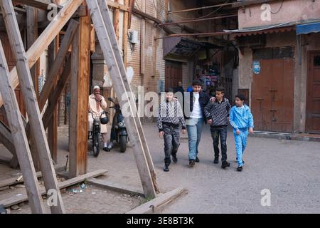 Group of children walking through a narrow street in a city. Marrakesh, Morocco Stock Photo