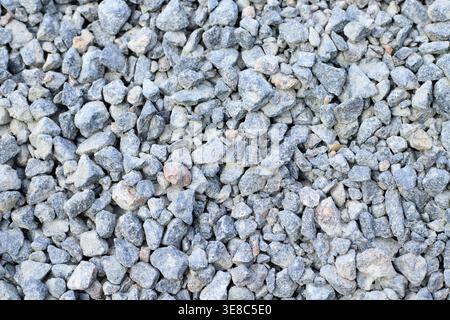 Top-view of grey granite gravel mixed with sand. Industrial aggregate for durable road foundations, drainage systems, and professional landscaping at Stock Photo
