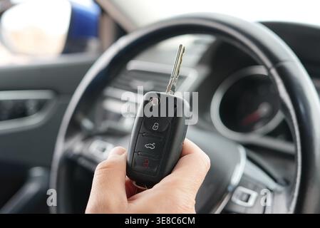 Hand holding car key inside vehicle close up auto ownership Stock Photo