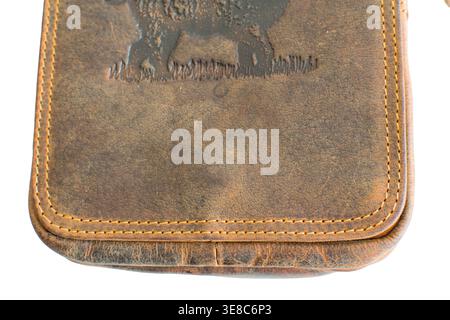 Vintage brown leather shoulder bag with embossed wild boar motif, hunter style crossbody messenger bag on white background. Stock Photo