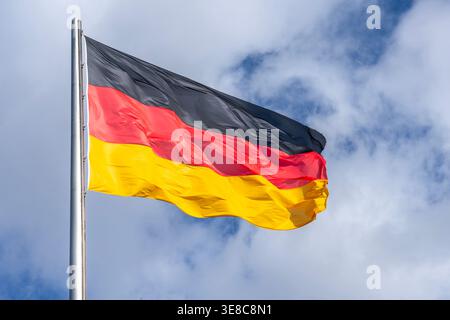 National German Flag in Sunshine. German flag waving in a strong breeze in the sun. Stock Photo