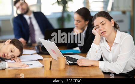 Group of tired colleagues working on laptop Stock Photo
