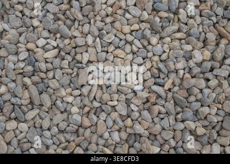 Top down view of a dense bed of smooth multi colored river pebbles and small gravel stones. Stock Photo