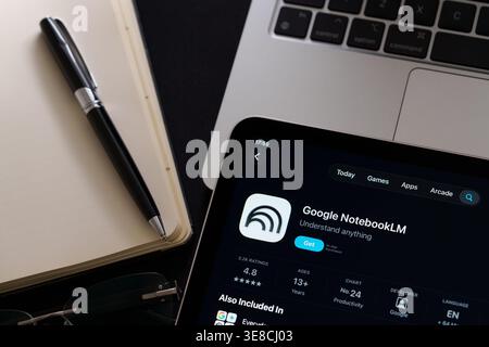 Google NotebookLM app on iPad with Apple Liquid Glass updated look and iOS 26 design on desk beside notebook and laptop. Stafford, United Kingdom, Apr Stock Photo