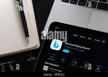 Microsoft Bing app on iPad with Apple Liquid Glass updated look and iOS 26 design on desk beside notebook and laptop. Stafford, United Kingdom, April Stock Photo