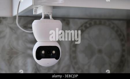 White Indoor Security Camera Mounted on Ceiling Stock Photo