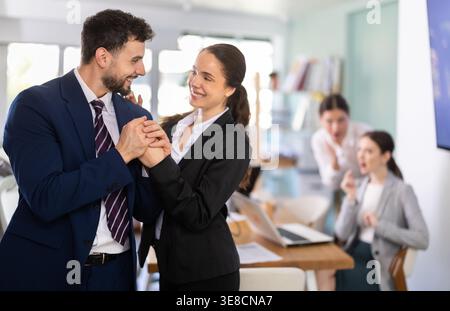 Man and woman holding hands in office Stock Photo