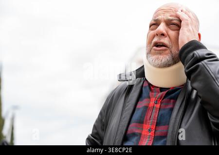 Man wearing a cervical collar experiencing pain and discomfort after an injury Stock Photo