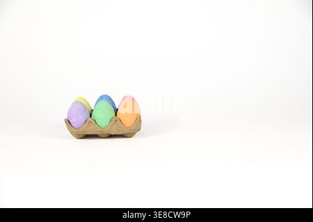 Easter basket stuffer of cardboard egg tray holding six brightly colored chalk Easter eggs Stock Photo