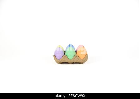Easter basket stuffer of cardboard egg tray holding six brightly colored chalk Easter eggs Stock Photo