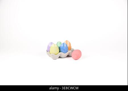 Easter basket stuffer of ceramic egg tray holding six brightly colored chalk Easter eggs Stock Photo