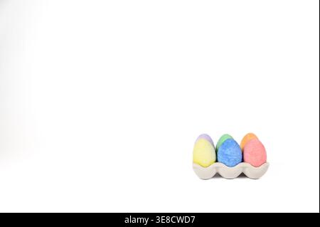 Easter basket stuffer of ceramic egg tray holding six brightly colored chalk Easter eggs Stock Photo
