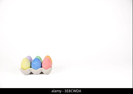 Easter basket stuffer of ceramic egg tray holding six brightly colored chalk Easter eggs Stock Photo