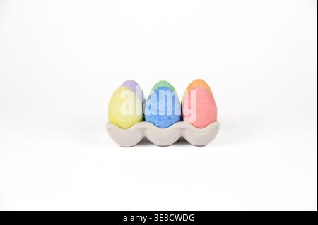 Easter basket stuffer of ceramic egg tray holding six brightly colored chalk Easter eggs Stock Photo