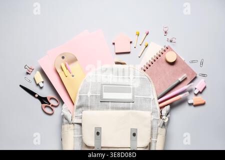 Stylish school backpack and different stationery on grey background Stock Photo