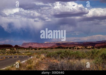 Dramatic storm clouds and rain over the red rock mesas of Canyonlands National Park, Utah. Summer monsoon weather over a vast desert landscape. Stock Photo