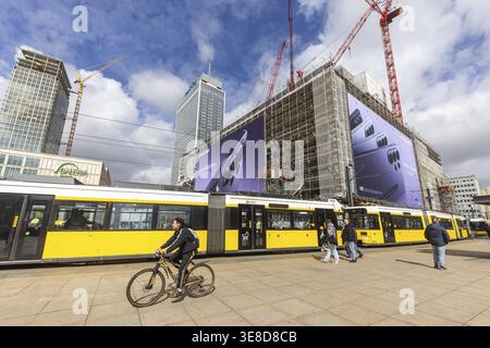 View of Alexanderplatz in Berlin. Covivio Tower and The Berlinian construction sites. Megaposter advertising poster and a tram. Berlin, Germany Stock Photo