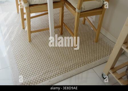 Rug and chairs in a bright room with tiled floor Stock Photo