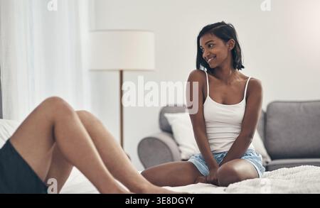 Happy woman, relax and bed in home with partner, connection and cozy on break with affection in morning. Couple, relationship and smile with laying Stock Photo