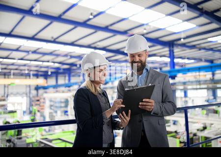 Industrial team analyzing data in high tech manufacturing plant. Stock Photo