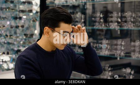 Confused man with glasses touching head and thinking Stock Photo