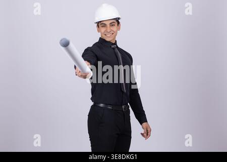Engineer in white helmet holding a blueprint tube in studio Stock Photo