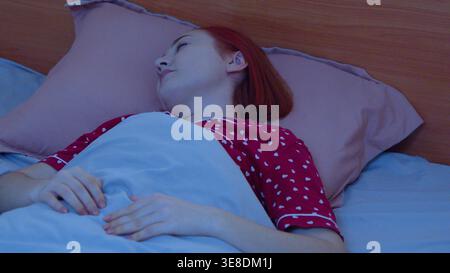 Young woman sleeping peacefully in a comfortable bed Stock Photo