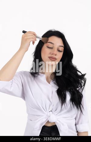 Woman applying powder with a makeup brush Stock Photo