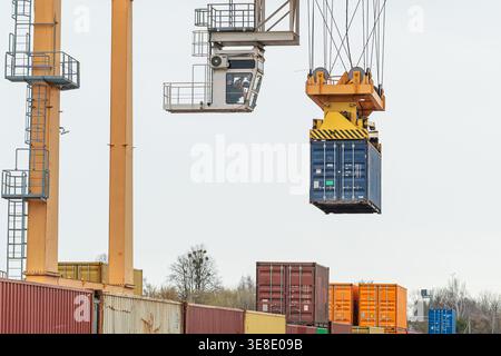 Gantry crane lifting a blue shipping container at an intermodal ...