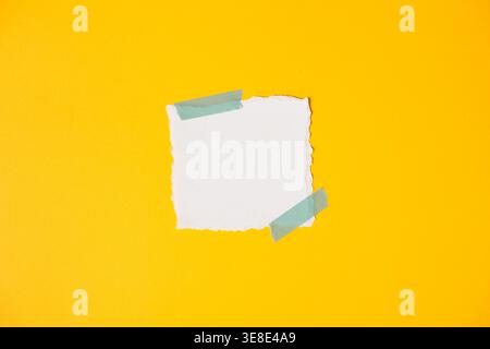 Empty ripped paper label on bright yellow minimal backdrop Stock Photo