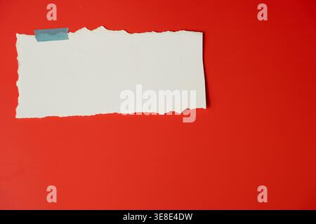 Empty ripped paper label on bright red backdrop minimal design Stock Photo